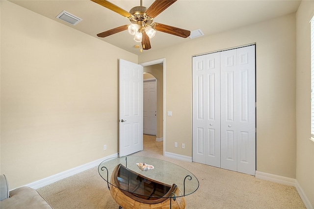 living area with light carpet and ceiling fan