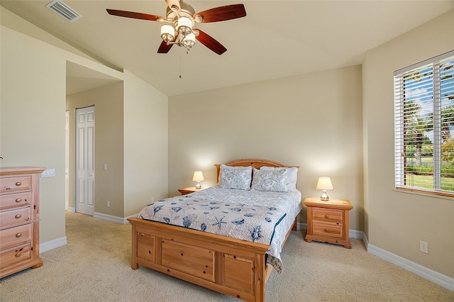 carpeted bedroom with ceiling fan and vaulted ceiling