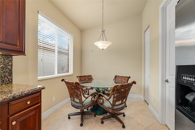 tiled dining space featuring vaulted ceiling