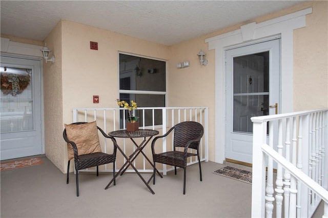 property entrance with a porch and stucco siding