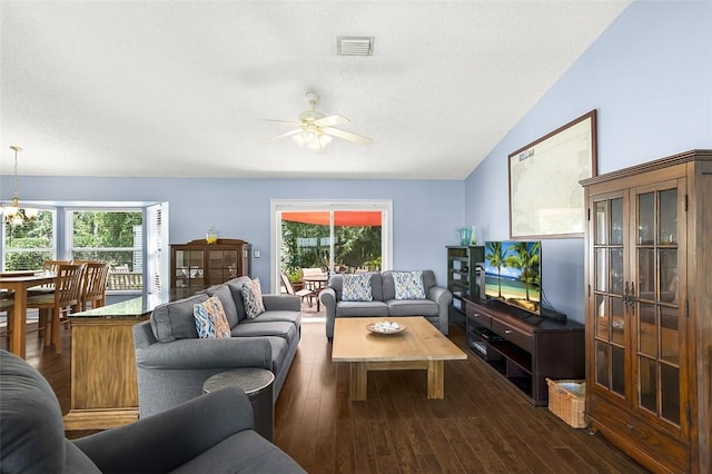 living room featuring dark wood finished floors, visible vents, vaulted ceiling, a textured ceiling, and ceiling fan