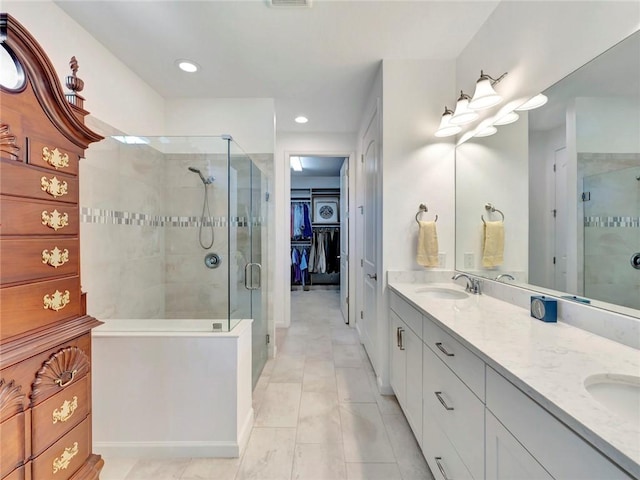 5205 Turtle Creek Cir, Vero Beach, FL 32967 - full bathroom featuring double vanity, a spacious closet, a stall shower, and recessed lighting