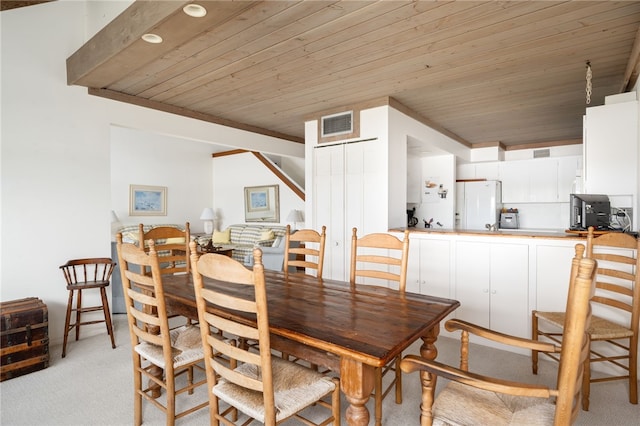 carpeted dining space featuring wooden ceiling