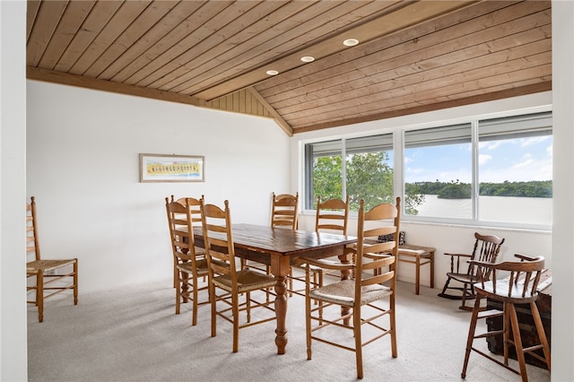 carpeted dining room featuring lofted ceiling, wooden ceiling, and a water view