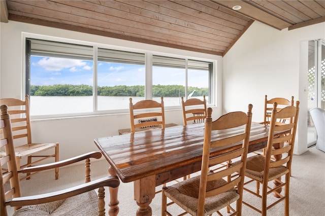 dining area featuring a water view, vaulted ceiling, light carpet, and wooden ceiling