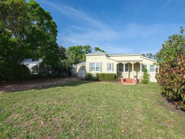 2237 10th Ave, Vero Beach, FL 32960 - exterior space with metal roof, stucco siding, a standing seam roof, a lawn, and a garage