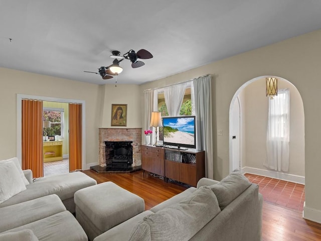 2237 10th Ave, Vero Beach, FL 32960 - living area featuring wood finished floors, arched walkways, baseboards, a fireplace, and ceiling fan