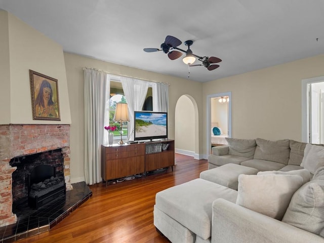 2237 10th Ave, Vero Beach, FL 32960 - living area featuring arched walkways, baseboards, a brick fireplace, wood finished floors, and ceiling fan