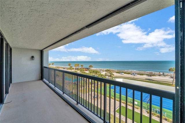 balcony featuring a water view and a beach view