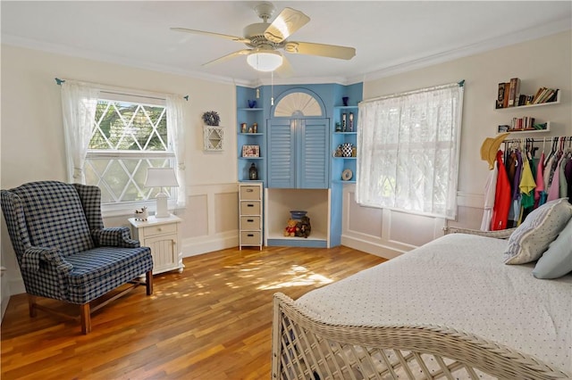 bedroom with ornamental molding, ceiling fan, and light wood-type flooring