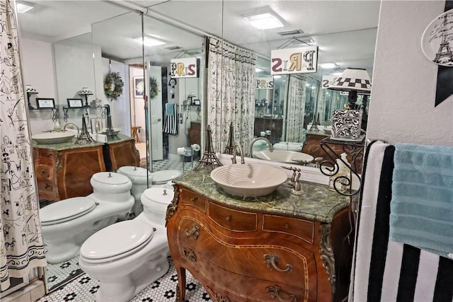 bathroom with vanity, toilet, tile patterned flooring, and a shower