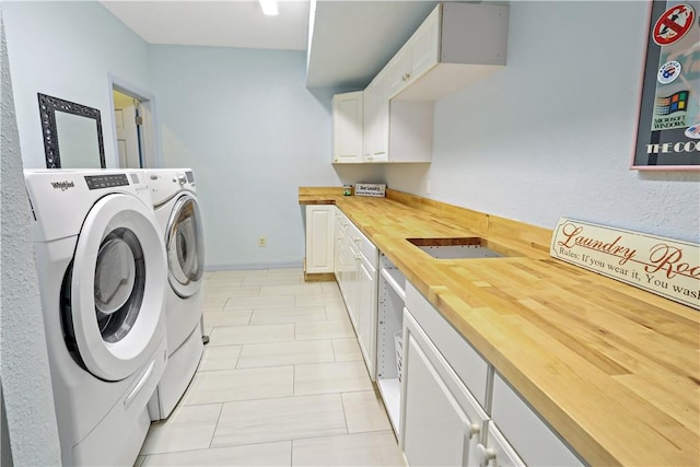 clothes washing area with cabinets and washer and dryer