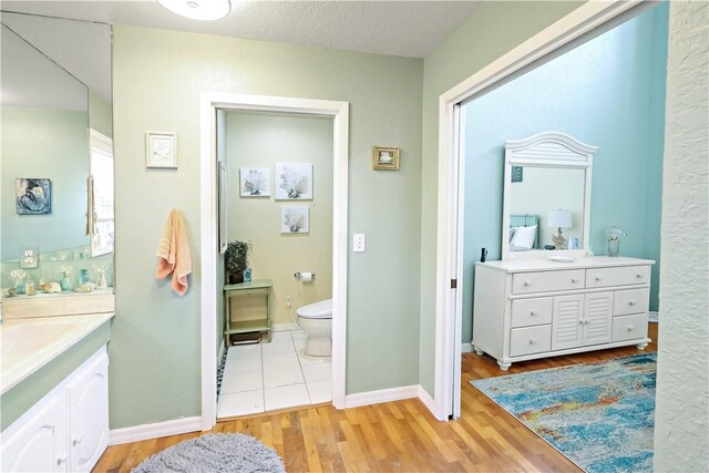 bathroom featuring vanity, toilet, and hardwood / wood-style floors