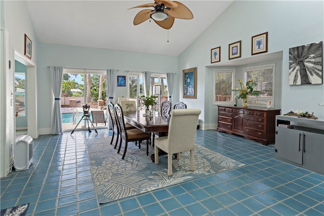 tiled dining space featuring ceiling fan and high vaulted ceiling