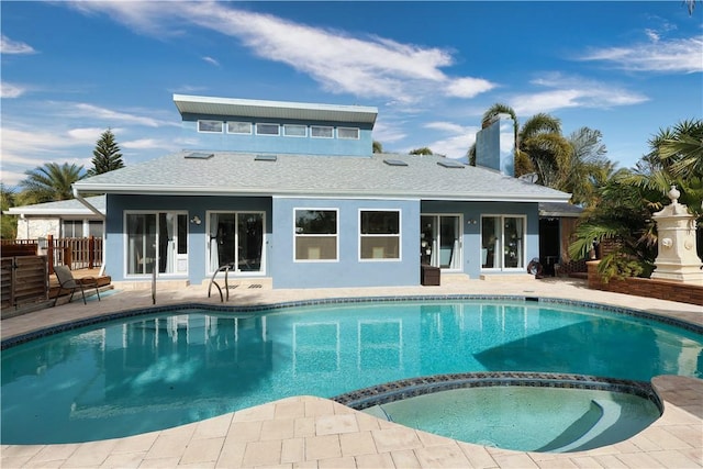 back of property featuring a patio area and a pool with hot tub