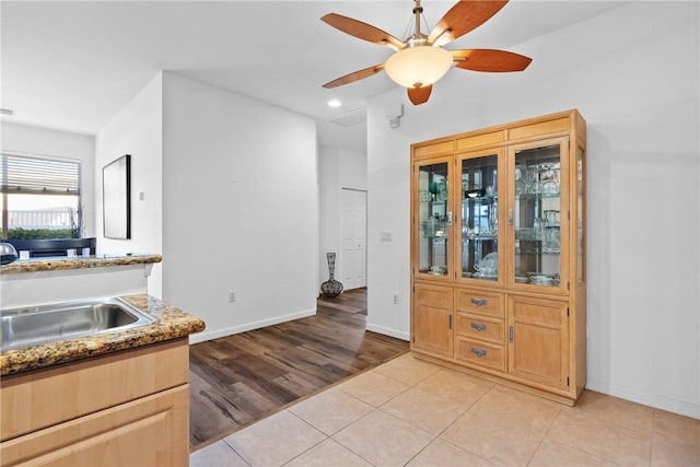 interior space featuring ceiling fan, light tile patterned flooring, recessed lighting, a sink, and baseboards