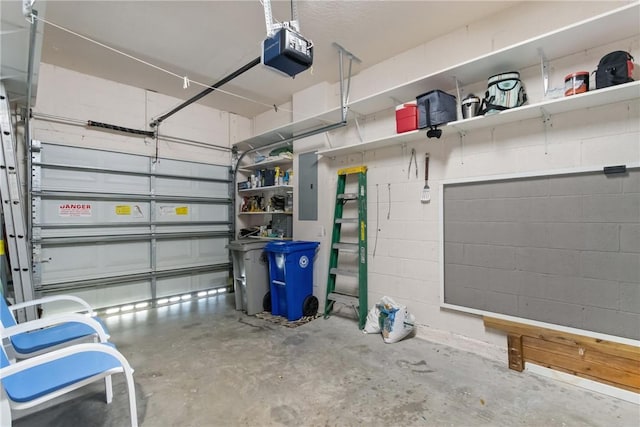 garage with concrete block wall, electric panel, and a garage door opener