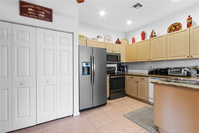 kitchen featuring appliances with stainless steel finishes, light brown cabinetry, visible vents, and light tile patterned floors