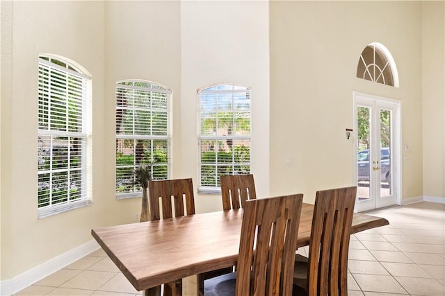 6139 57th Ct, Vero Beach, FL 32967 - dining area featuring a towering ceiling, light tile patterned floors, french doors, and baseboards