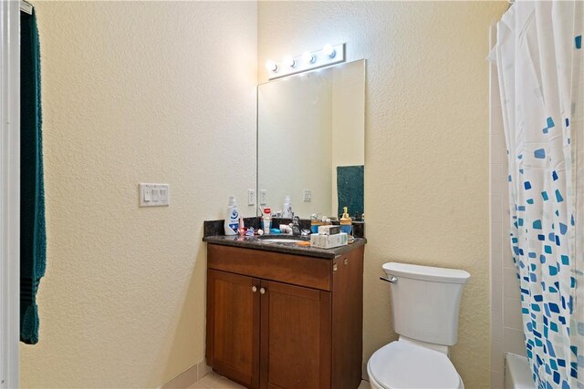 6139 57th Ct, Vero Beach, FL 32967 - bathroom featuring toilet, vanity, a textured wall, and shower / bathtub combination with curtain