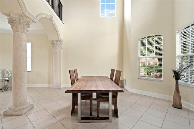 6139 57th Ct, Vero Beach, FL 32967 - tiled dining area featuring ornate columns, a towering ceiling, ornamental molding, baseboards, and arched walkways