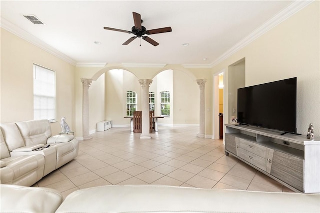 6139 57th Ct, Vero Beach, FL 32967 - living area featuring ornate columns, arched walkways, light tile patterned floors, ceiling fan, and crown molding