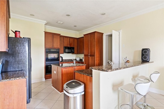 6139 57th Ct, Vero Beach, FL 32967 - kitchen with black appliances, light tile patterned floors, a breakfast bar area, dark stone counters, and baseboards