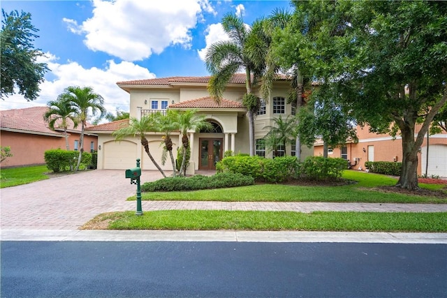 6139 57th Ct, Vero Beach, FL 32967 - mediterranean / spanish-style house with stucco siding, driveway, a tiled roof, and a front yard