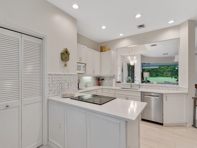 kitchen with sink, stainless steel dishwasher, kitchen peninsula, black electric cooktop, and white cabinets