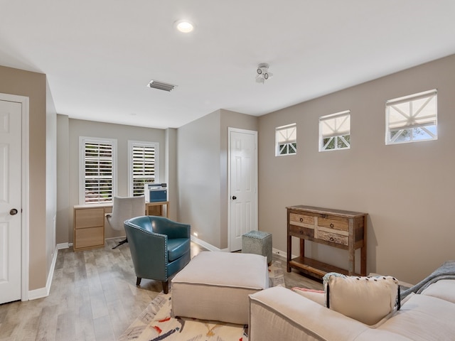 living room with a wealth of natural light and light hardwood / wood-style flooring