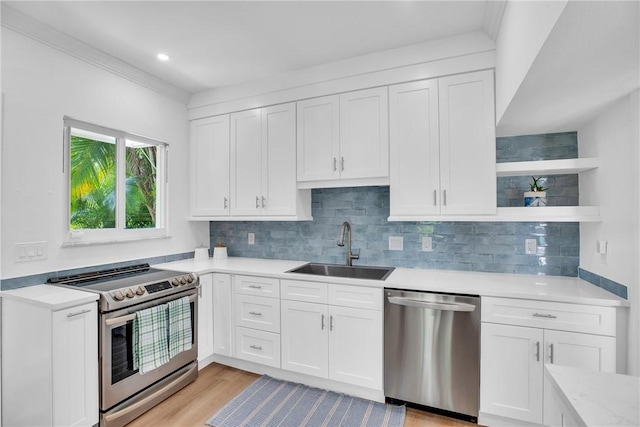 811 Royal Palm Pl, Vero Beach, FL 32960 - kitchen featuring appliances with stainless steel finishes, light countertops, white cabinets, backsplash, and light wood finished floors