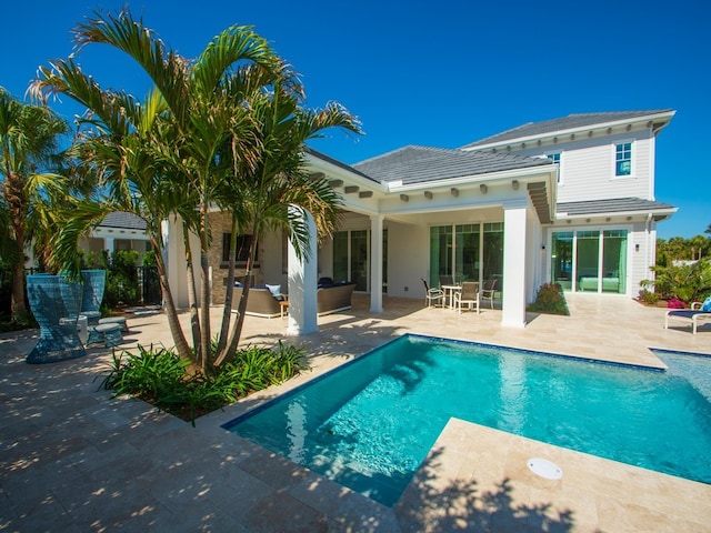 back of house with an outdoor living space and a patio area