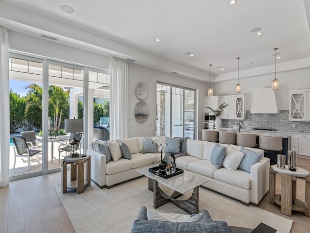 909 Surfsedge Way, Vero Beach, FL 32963 - living area featuring light wood-style floors, recessed lighting, and a tray ceiling