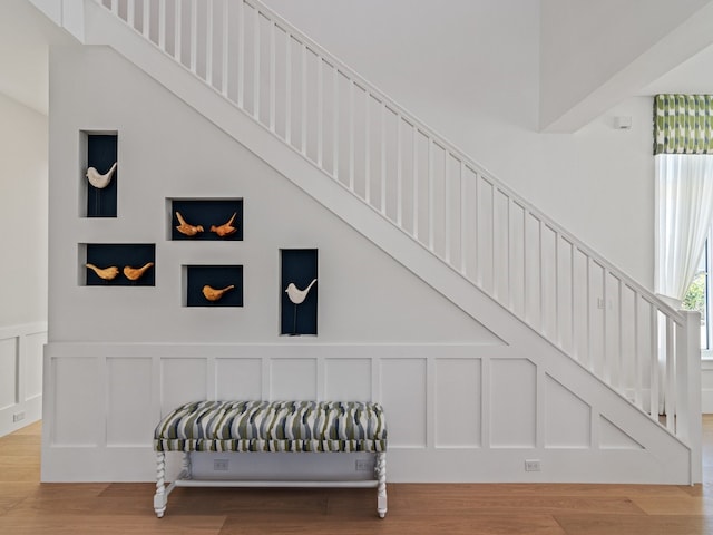 stairway with hardwood / wood-style flooring and a high ceiling