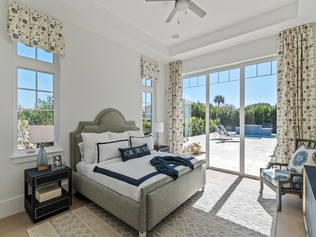 bedroom with hardwood / wood-style flooring, ceiling fan, access to outside, and multiple windows