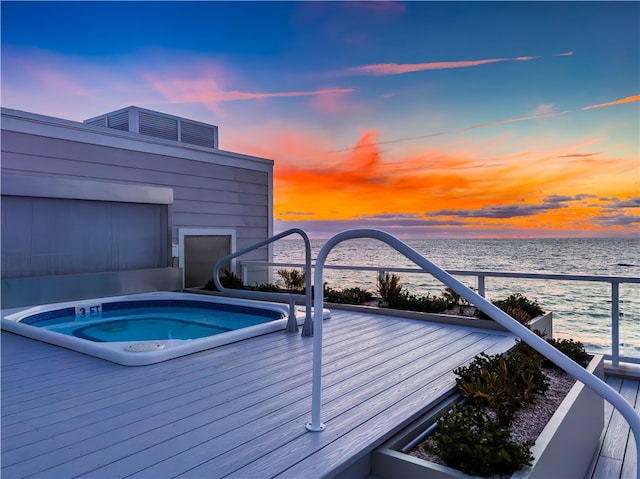 pool at dusk featuring a water view and an outdoor hot tub