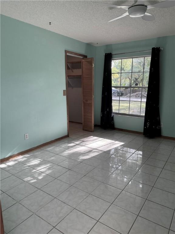2380 89th Ave, Vero Beach, FL 32966 - unfurnished room featuring light tile patterned floors, a textured ceiling, and a ceiling fan
