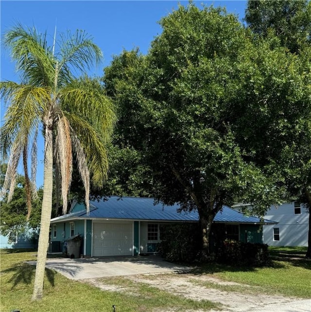 2380 89th Ave, Vero Beach, FL 32966 - ranch-style home featuring an attached garage, driveway, a front yard, and a metal roof