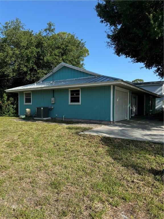 2380 89th Ave, Vero Beach, FL 32966 - view of side of home with an attached garage and a lawn
