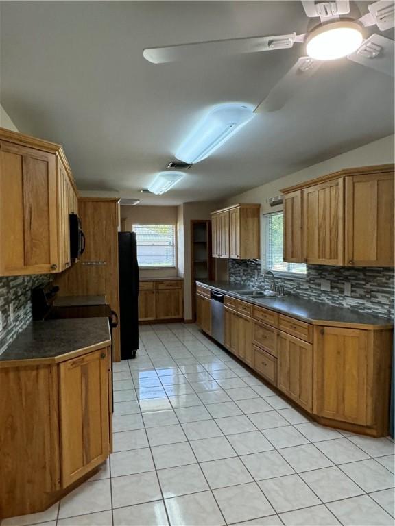 2380 89th Ave, Vero Beach, FL 32966 - kitchen featuring black appliances, light tile patterned floors, backsplash, and dark countertops