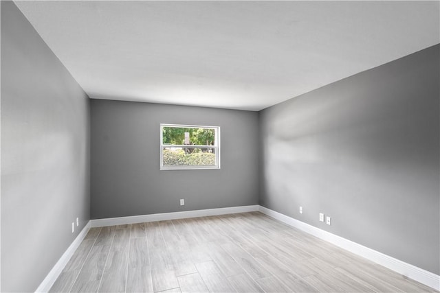 empty room with baseboards and light wood-style floors