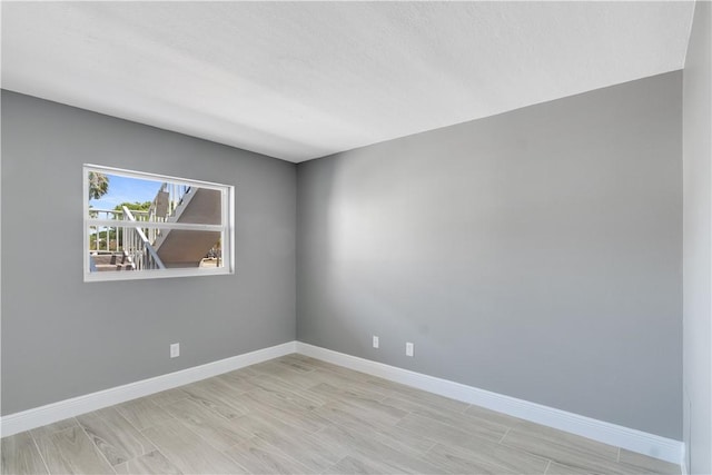 unfurnished room featuring baseboards and wood finished floors