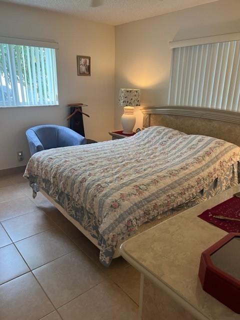 bedroom featuring tile patterned floors and baseboards
