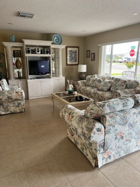 tiled living room featuring a textured ceiling