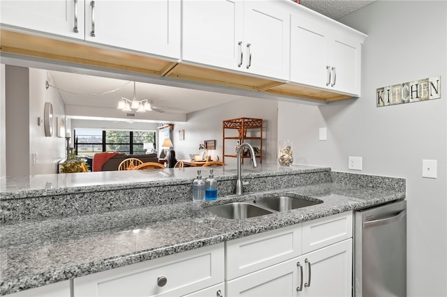 kitchen with white cabinetry, sink, light stone counters, an inviting chandelier, and dishwasher