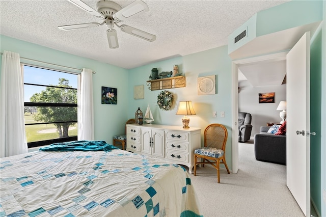 carpeted bedroom with ceiling fan and a textured ceiling