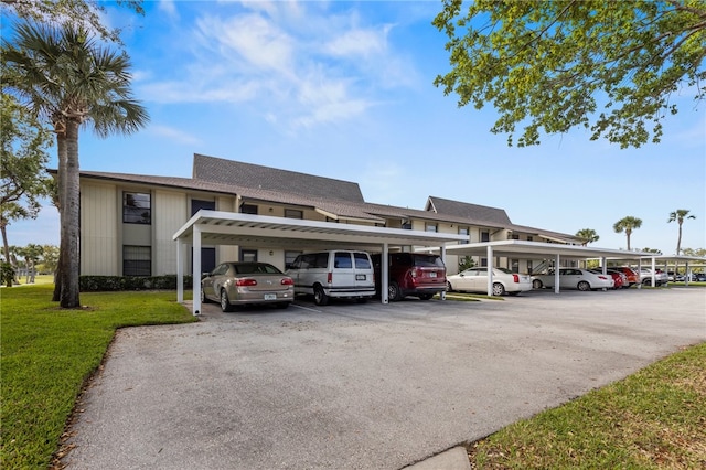 view of vehicle parking featuring a yard and a carport