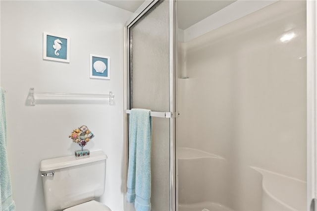 bathroom featuring toilet and an enclosed shower