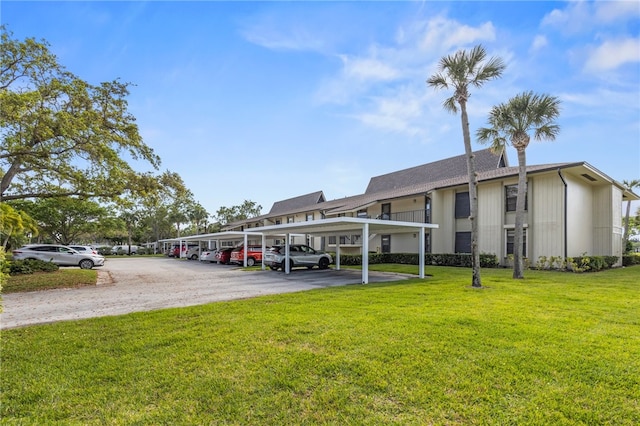 view of vehicle parking with a lawn and a carport