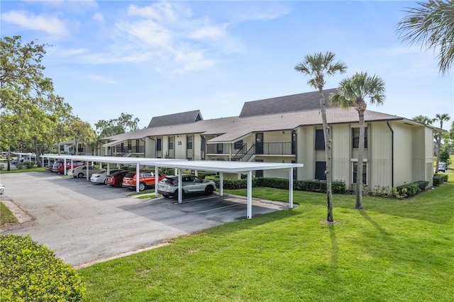 view of parking / parking lot with a lawn and a carport